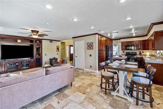 kitchen featuring ceiling fan, ornamental molding, black appliances, light countertops, and a sink