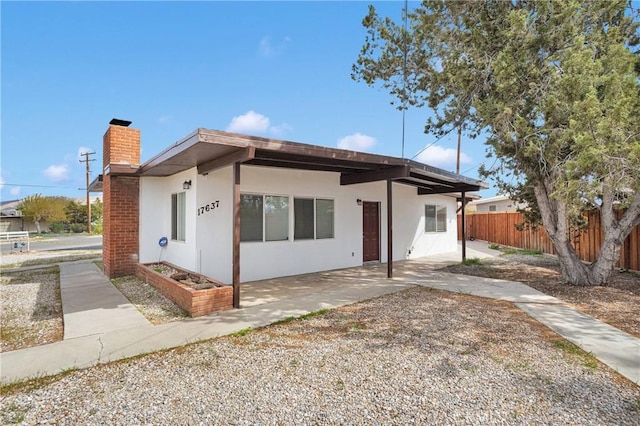 17637 Sultana St, Hesperia, CA 92345 - view of front of home with a patio area, stucco siding, fence, and a chimney