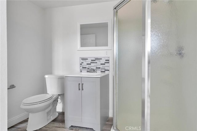 17637 Sultana St, Hesperia, CA 92345 - bathroom featuring toilet, vanity, wood finished floors, backsplash, and a stall shower