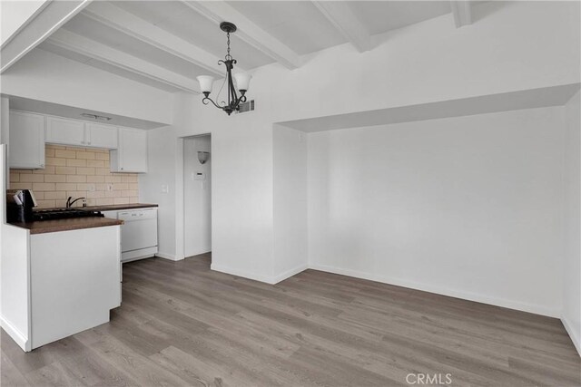17637 Sultana St, Hesperia, CA 92345 - kitchen with light wood-style floors, white cabinets, dishwasher, dark countertops, and a notable chandelier