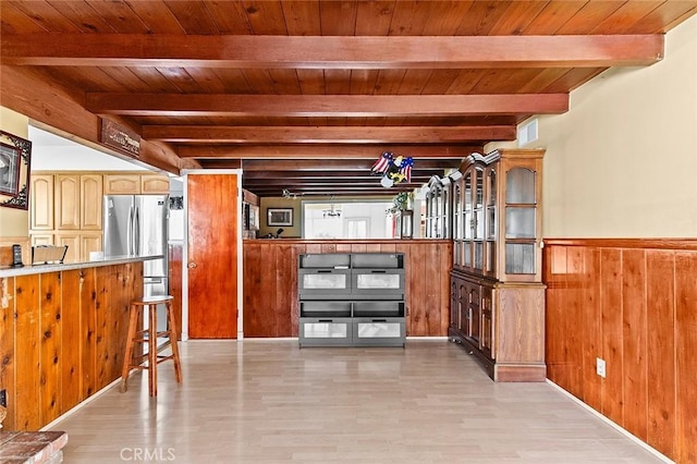 interior space featuring wood ceiling, light wood-style flooring, beamed ceiling, wood walls, and visible vents