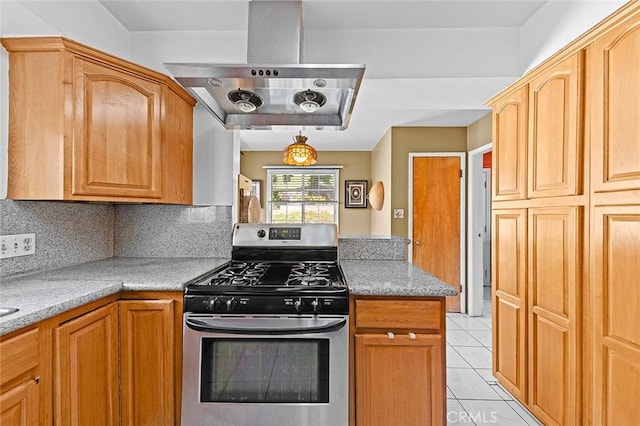 kitchen featuring stainless steel range with gas stovetop, light tile patterned flooring, exhaust hood, and decorative backsplash
