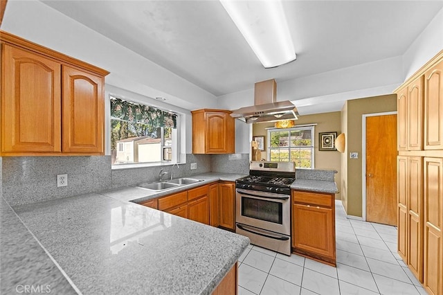kitchen featuring decorative backsplash, a sink, gas range, exhaust hood, and a peninsula