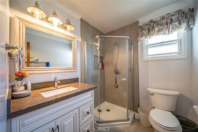 bathroom featuring toilet, vanity, a shower stall, and crown molding