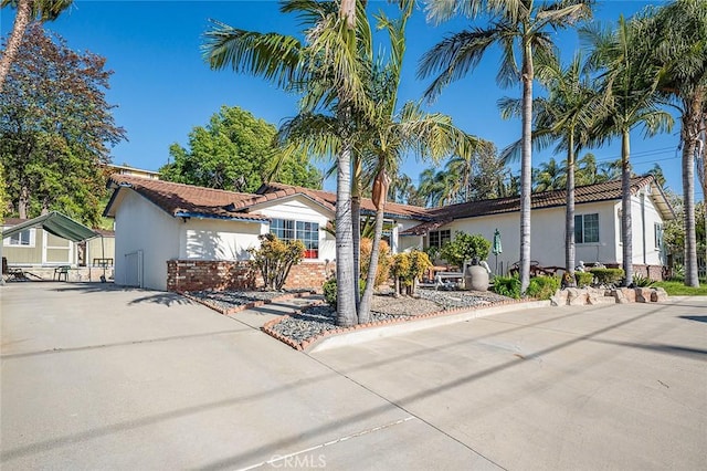 single story home featuring a tile roof and stucco siding