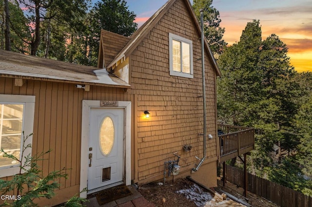 23624 Scenic Dr, Crestline, CA 92325 - exterior entry at dusk with a shingled roof and a deck