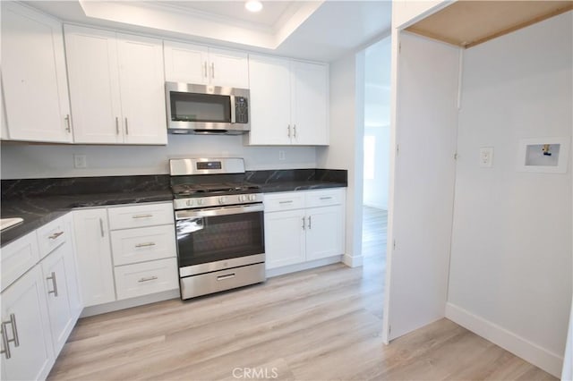 17114 Bluewater Ln Unit 141, Huntington Beach, CA 92649 - kitchen featuring stainless steel appliances, a tray ceiling, light wood finished floors, crown molding, and white cabinetry