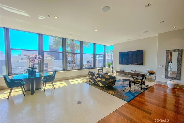 living area featuring baseboards, recessed lighting, and wood finished floors