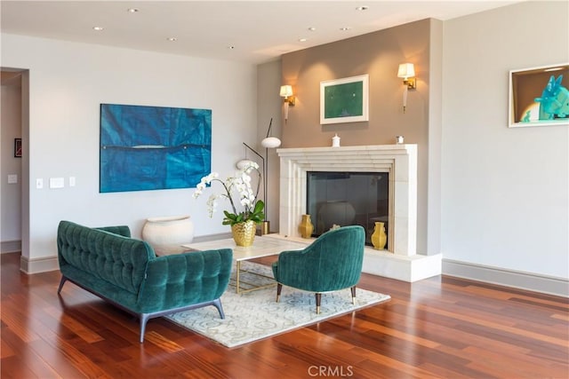 living room featuring wood finished floors, a fireplace, baseboards, and recessed lighting