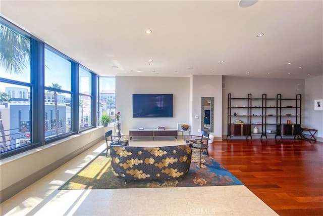 living room featuring baseboards, recessed lighting, and wood finished floors