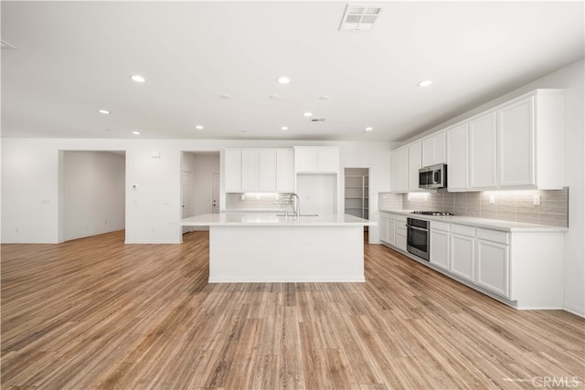 29391 Santa Ynez Cir, Menifee, CA 92584 - kitchen with light wood finished floors, appliances with stainless steel finishes, decorative backsplash, and recessed lighting