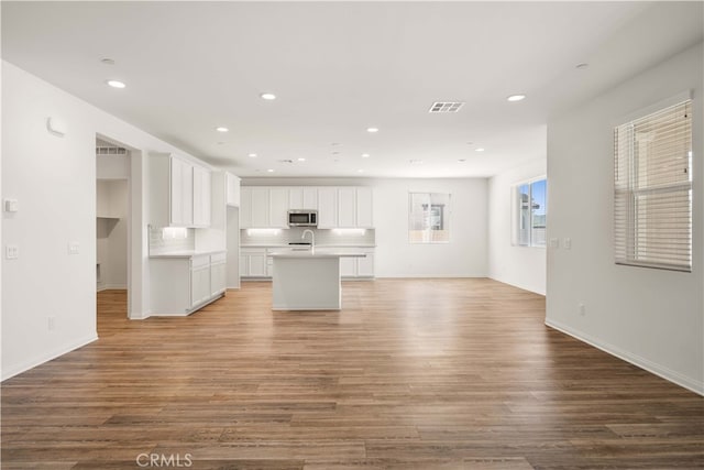 29391 Santa Ynez Cir, Menifee, CA 92584 - kitchen featuring visible vents, wood finished floors, stainless steel microwave, a sink, and open floor plan