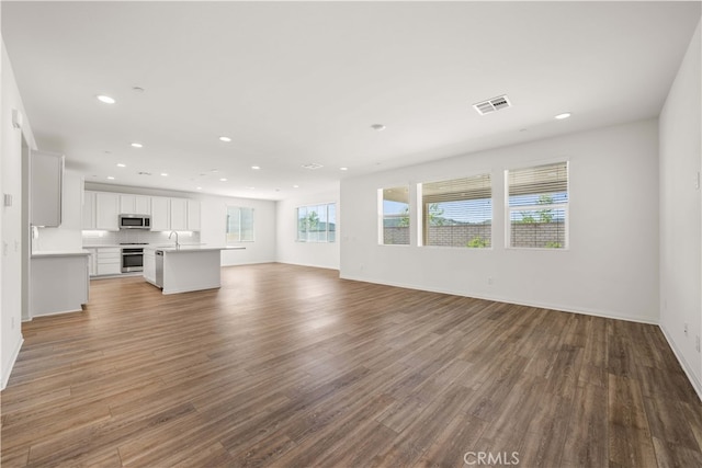29391 Santa Ynez Cir, Menifee, CA 92584 - unfurnished living room featuring visible vents, recessed lighting, wood finished floors, a sink, and baseboards