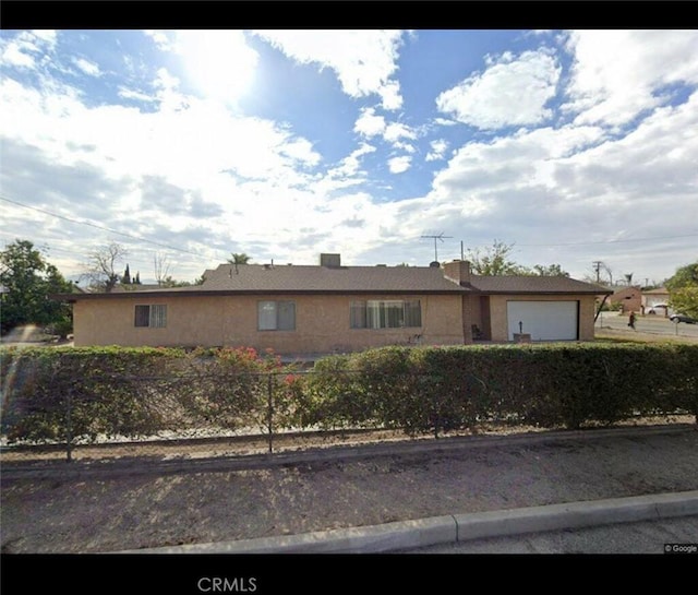 single story home with an attached garage and a fenced front yard