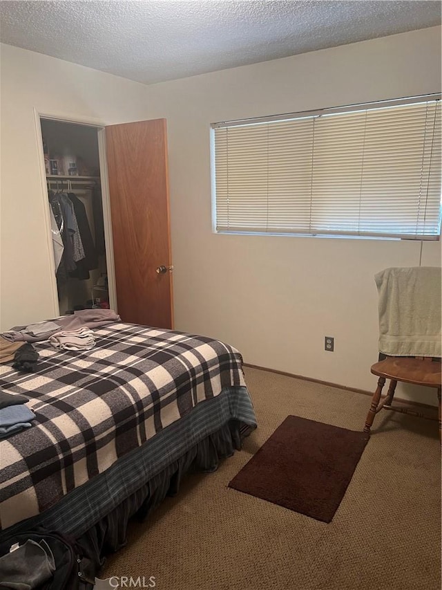 bedroom with a textured ceiling, a closet, and carpet floors