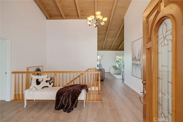 interior space featuring a chandelier, light wood-type flooring, beam ceiling, and wooden ceiling