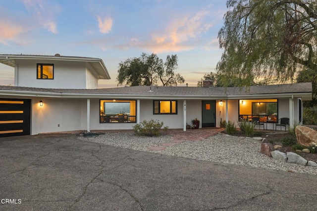 1417 Foothill Rd, Ojai, CA 93023 - view of front of home featuring covered porch, stucco siding, asphalt driveway, a chimney, and a garage