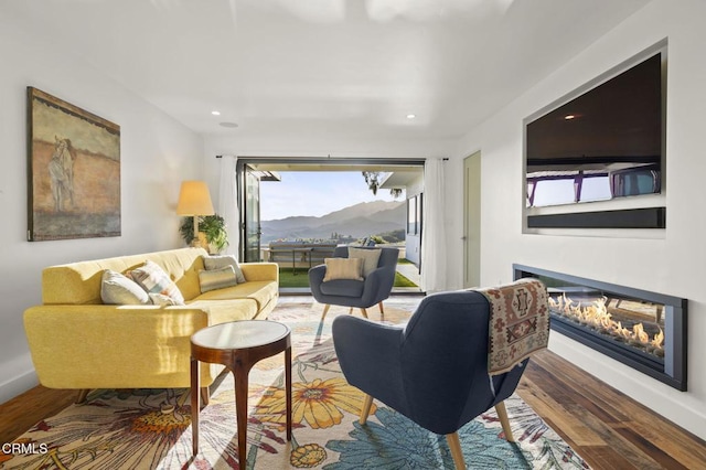 1417 Foothill Rd, Ojai, CA 93023 - living area with wood finished floors, a glass covered fireplace, recessed lighting, a mountain view, and baseboards