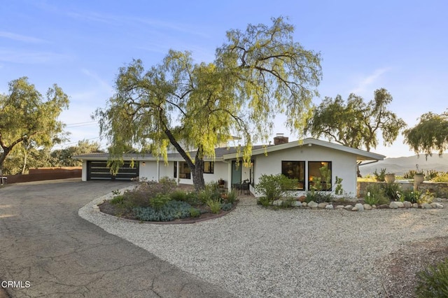 1417 Foothill Rd, Ojai, CA 93023 - view of front of home with driveway, a chimney, stucco siding, and an attached carport