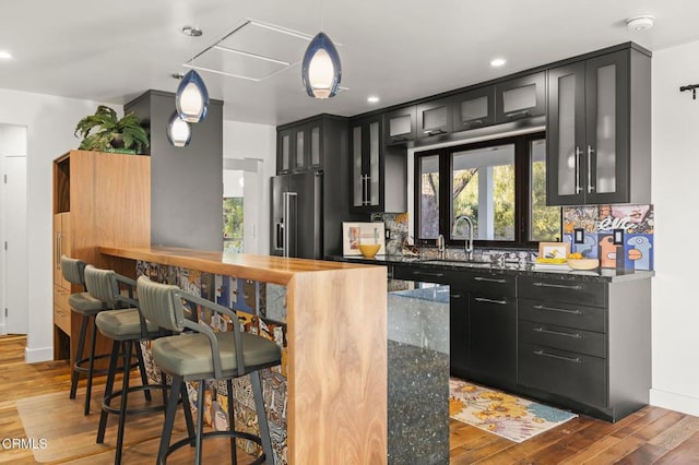 1417 Foothill Rd, Ojai, CA 93023 - kitchen featuring high quality fridge, dark cabinets, a sink, wood finished floors, and glass insert cabinets