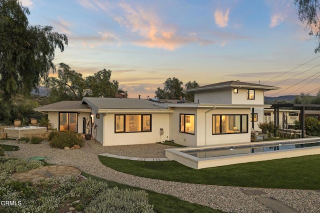 1417 Foothill Rd, Ojai, CA 93023 - back of house at dusk with stucco siding, a yard, and a patio