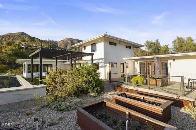 1417 Foothill Rd, Ojai, CA 93023 - rear view of property featuring a garden, a mountain view, stucco siding, and french doors