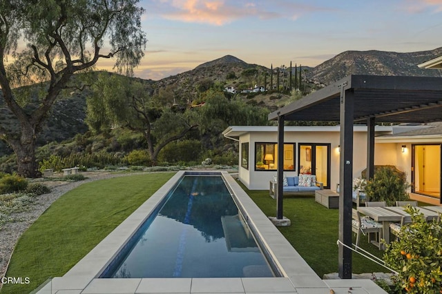 1417 Foothill Rd, Ojai, CA 93023 - pool at dusk with a mountain view, outdoor lounge area, a yard, and an outdoor pool