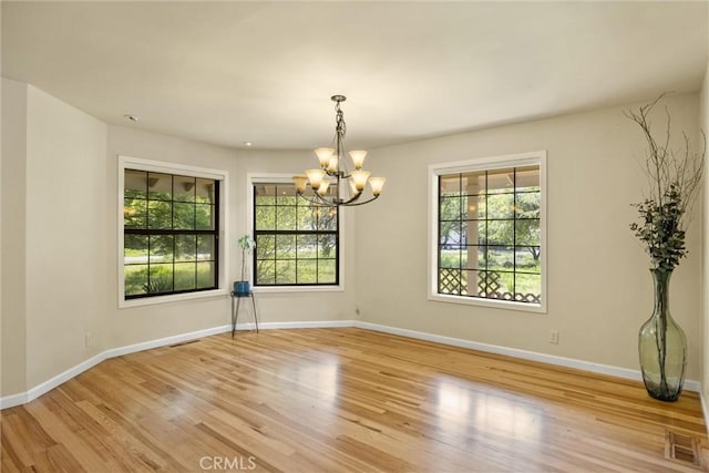15 Quadra Ct, Chico, CA 95928 - unfurnished room featuring a chandelier, healthy amount of natural light, wood finished floors, and baseboards