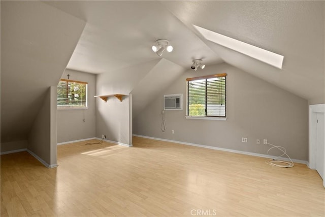 15 Quadra Ct, Chico, CA 95928 - additional living space featuring a skylight, light wood finished floors, plenty of natural light, lofted ceiling, and a wall mounted air conditioner