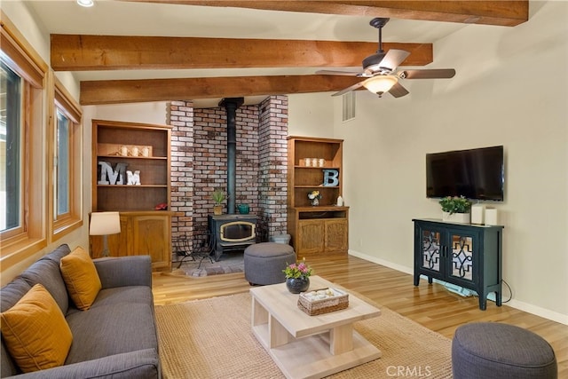 15 Quadra Ct, Chico, CA 95928 - living room with a wood stove, beamed ceiling, light wood-style floors, ceiling fan, and baseboards
