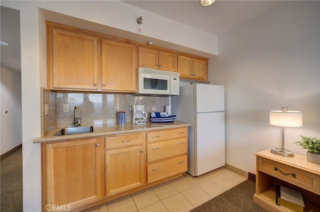kitchen featuring tasteful backsplash, baseboards, white appliances, light tile patterned floors, and a sink