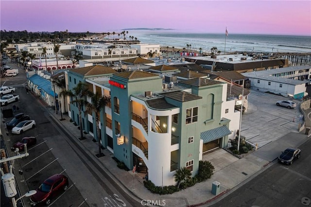 aerial view at dusk featuring a water view