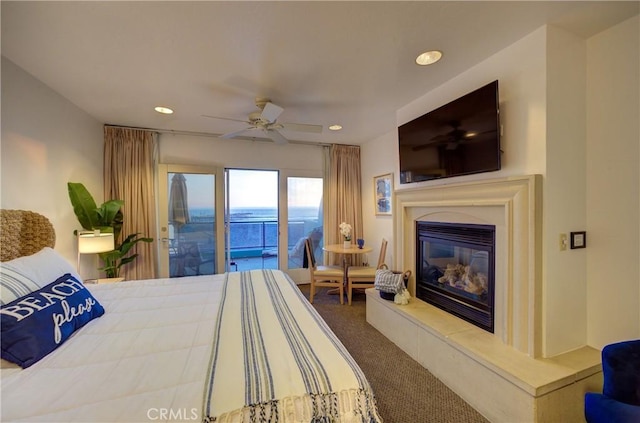 carpeted bedroom featuring access to outside, ceiling fan, a glass covered fireplace, and recessed lighting