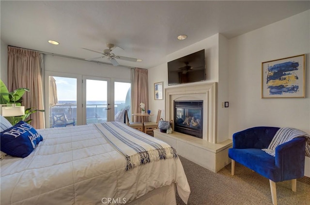 carpeted bedroom featuring recessed lighting, access to outside, a glass covered fireplace, and a ceiling fan