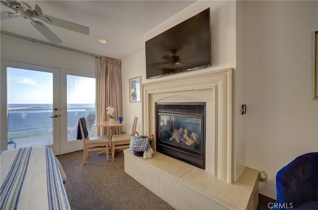 living area featuring french doors, a ceiling fan, carpet floors, and a high end fireplace