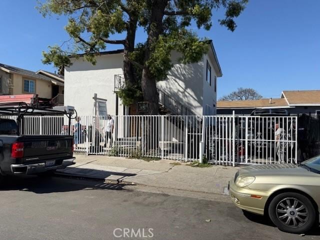 view of side of property featuring stucco siding and fence