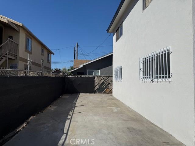 view of property exterior with a patio, stucco siding, and fence