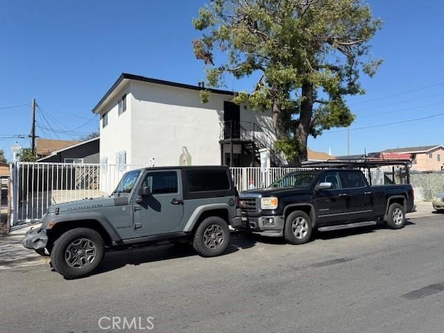 view of side of property featuring stucco siding and fence