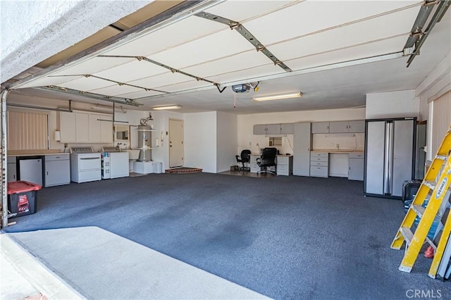 garage with freestanding refrigerator, fridge, water heater, washing machine and dryer, and a garage door opener