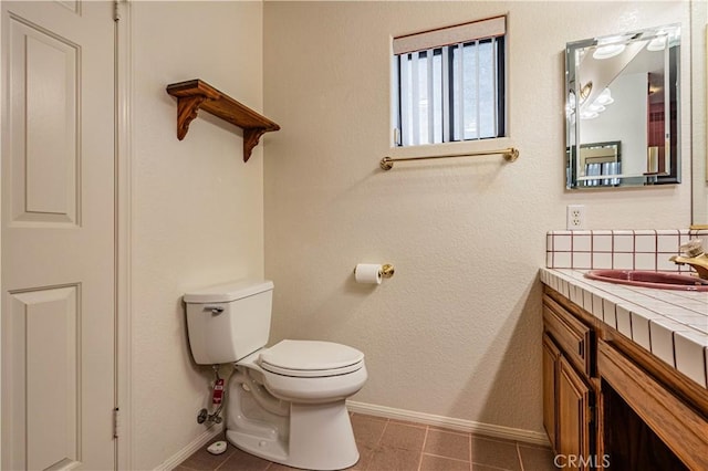 bathroom with tile patterned floors, baseboards, and toilet