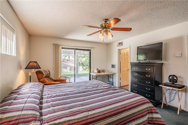 carpeted bedroom with access to outside, a textured ceiling, visible vents, and a ceiling fan