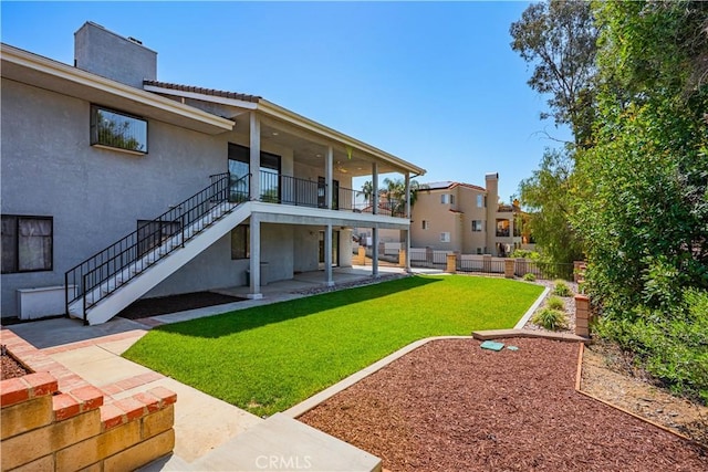 view of yard with a patio area, fence, and stairs