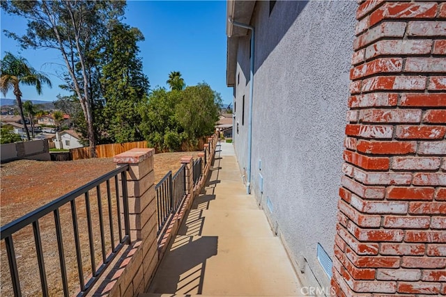 view of side of property with stucco siding and fence