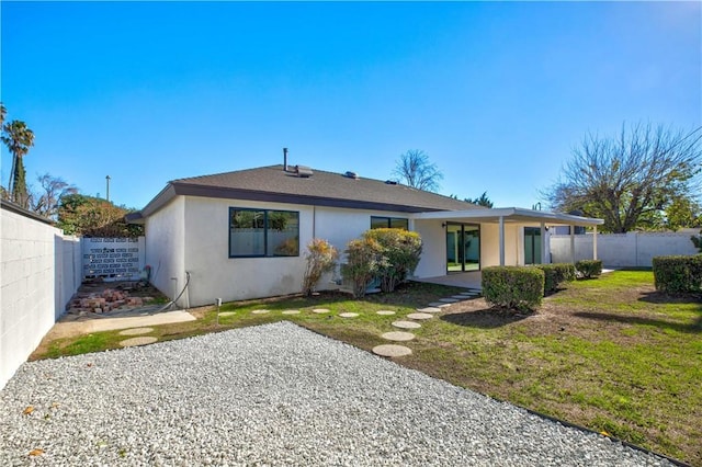 back of property with a yard, a fenced backyard, a patio, and stucco siding