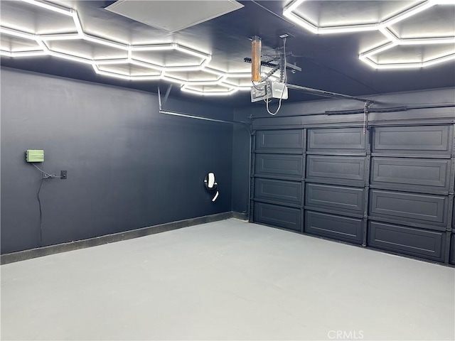 garage featuring a garage door opener and baseboards