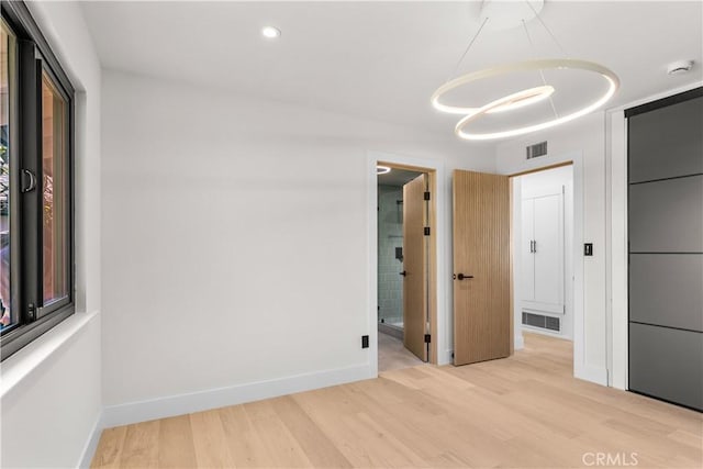 unfurnished room with visible vents, baseboards, and light wood-style floors