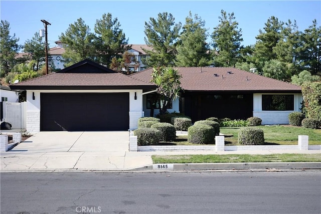 ranch-style house featuring a garage and concrete driveway