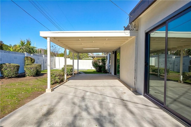 view of car parking with a carport and fence