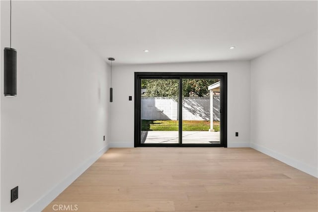 empty room with baseboards, recessed lighting, and light wood-style floors