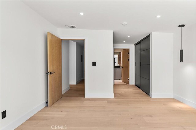 unfurnished room with light wood-style floors, recessed lighting, and visible vents